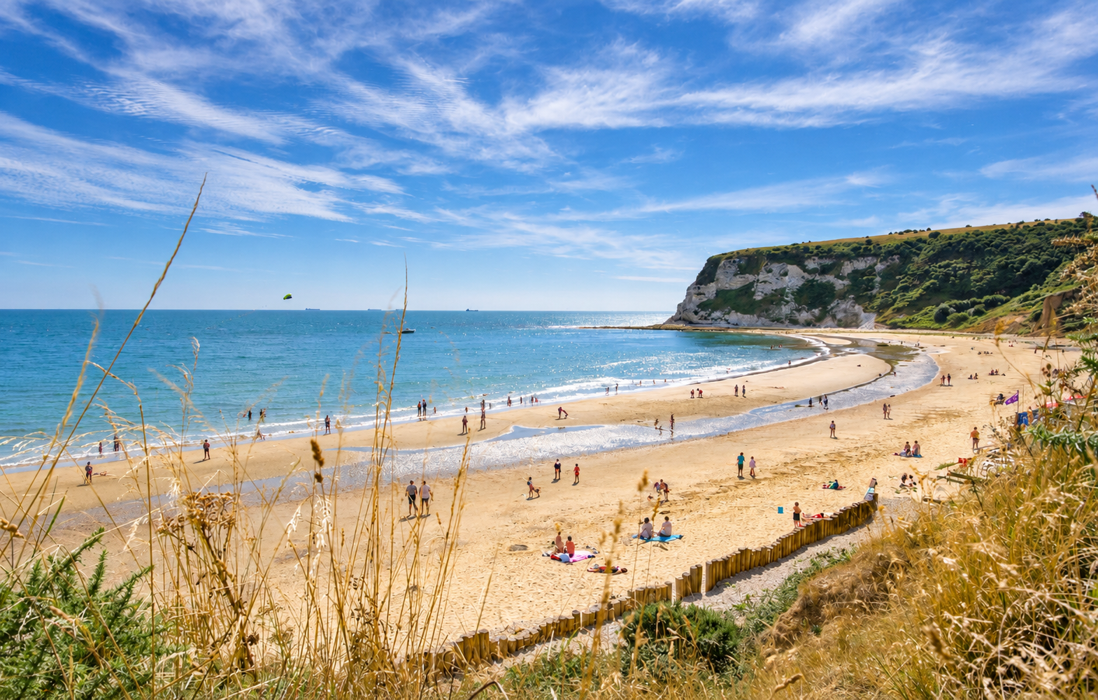 Families on the golden sands of Compton Bay beneath chalk cliffs on the Isle of Wight