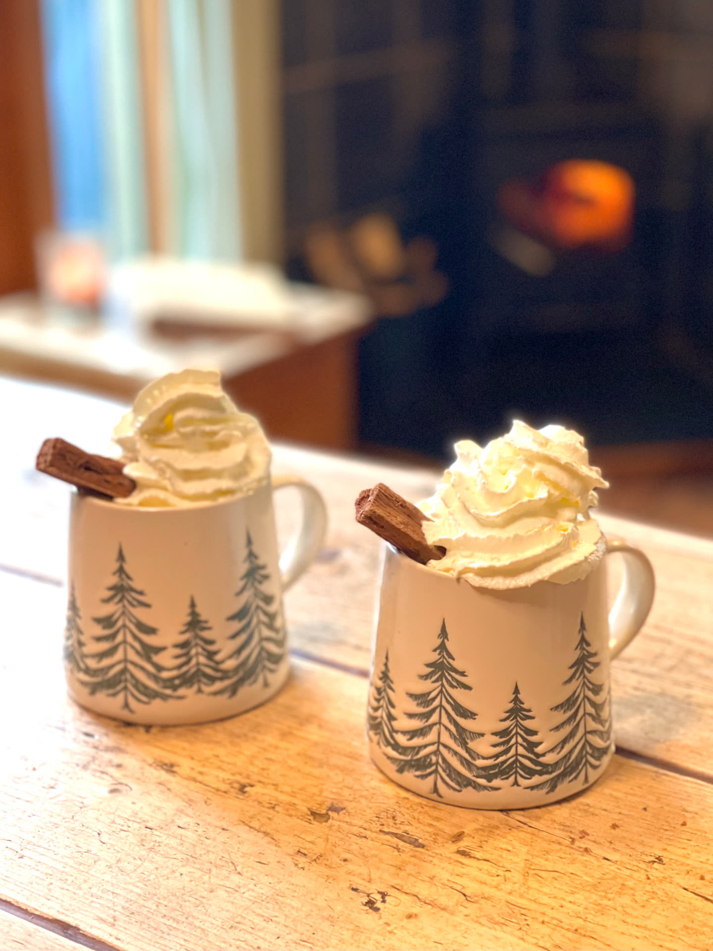 Two mugs of hot chocolate by the log burner