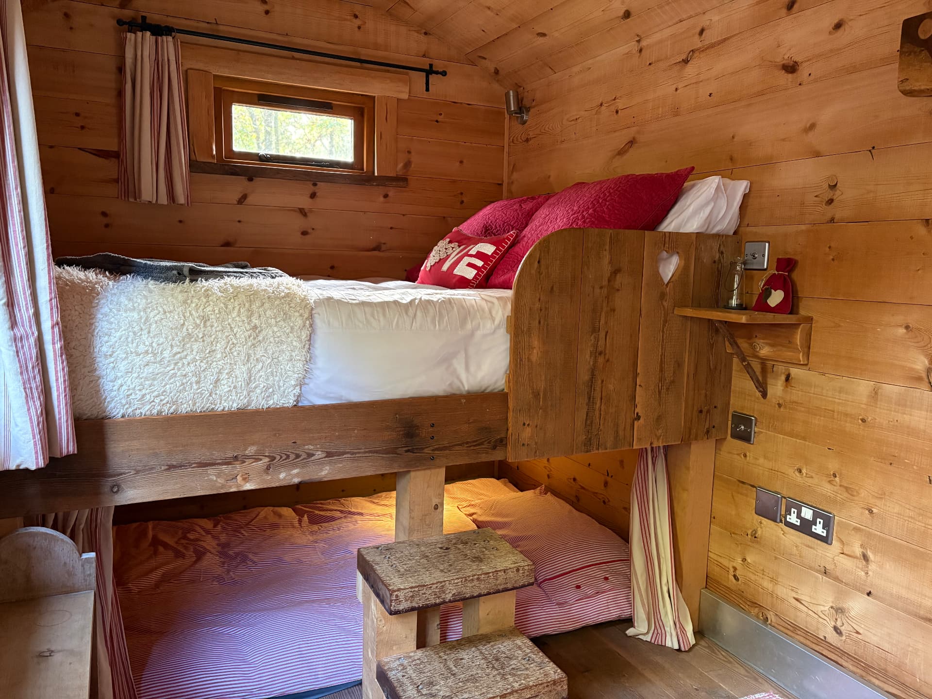 The Shepherd’s Hideaway double bunk — red LOVE cushion, striped bedding and wooden steps