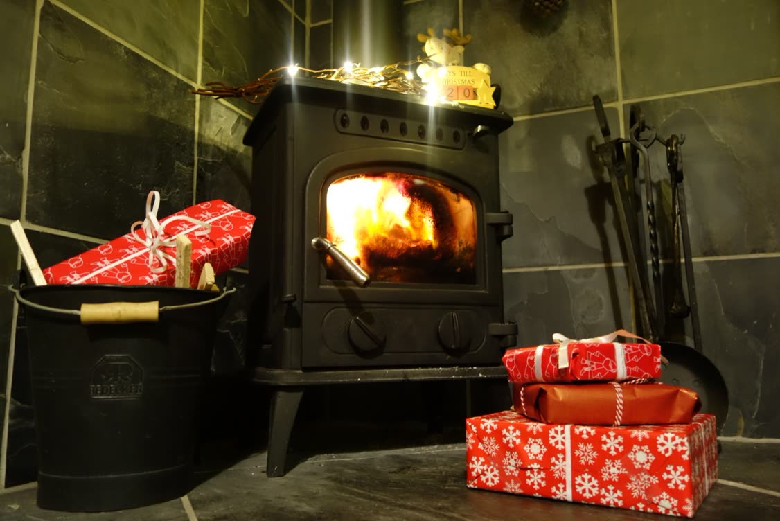Log burner with wrapped presents and fairy lights